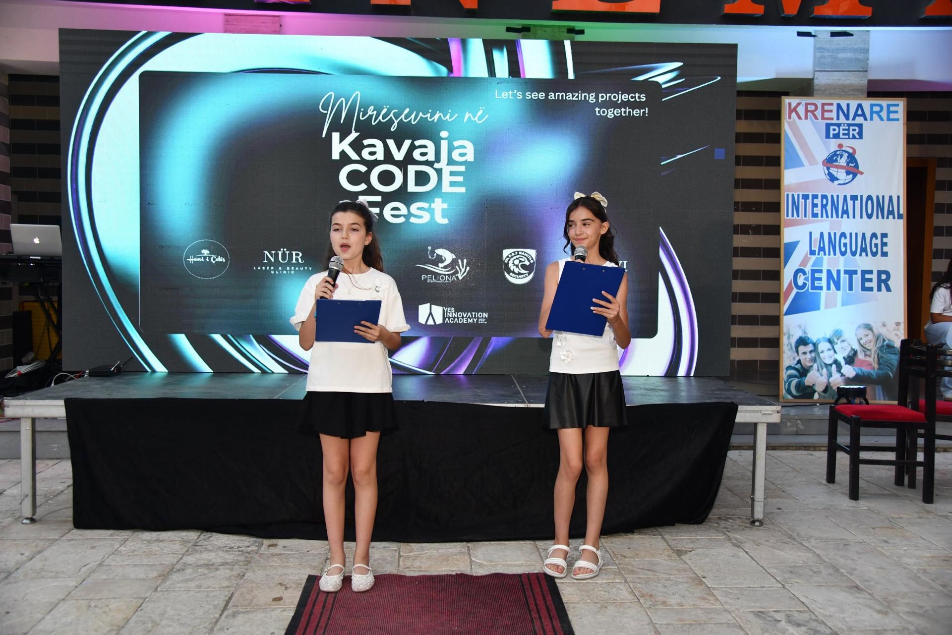 Two students presenting on stage at Kavaja Code Fest
